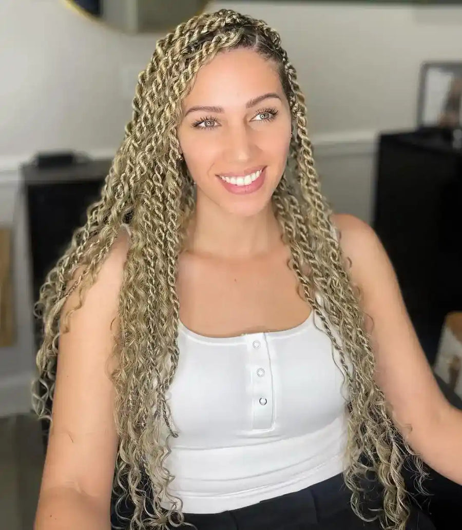 Woman with long, braided hair smiling indoors