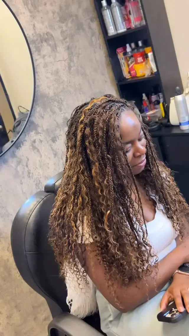 Woman with styled hair sitting in a salon chair, surrounded by salon products on shelves.