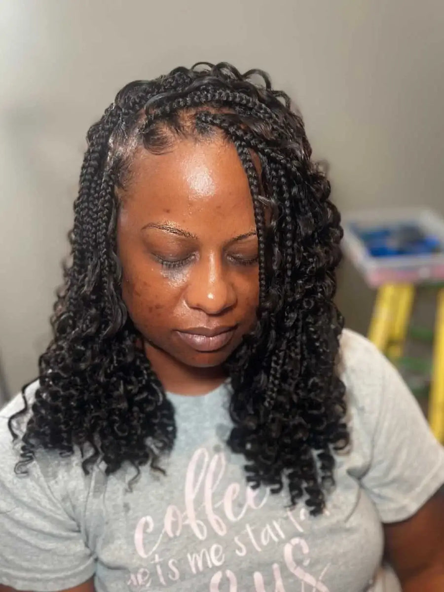 Woman with braided hair wearing a gray t-shirt with text.