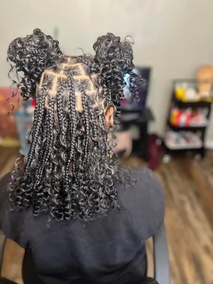 Person with styled hair in braids at a salon.