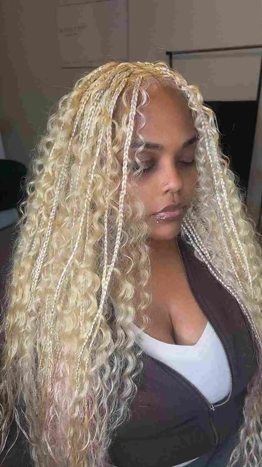 Woman with long, blonde, curly hair styled in a lace front wig.