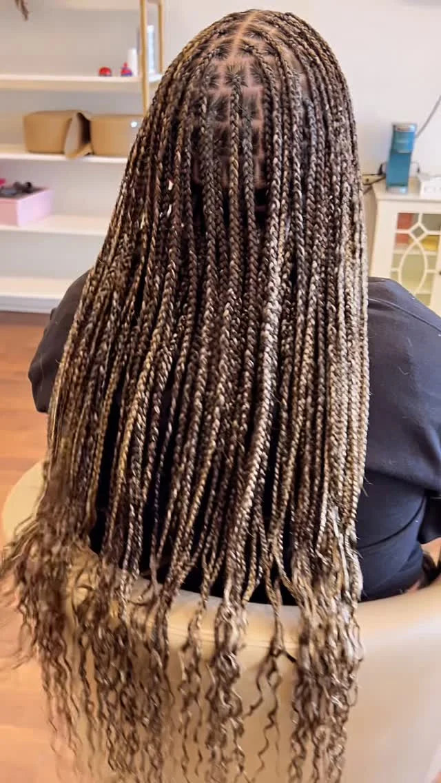 Person with long braided hair in a salon setting