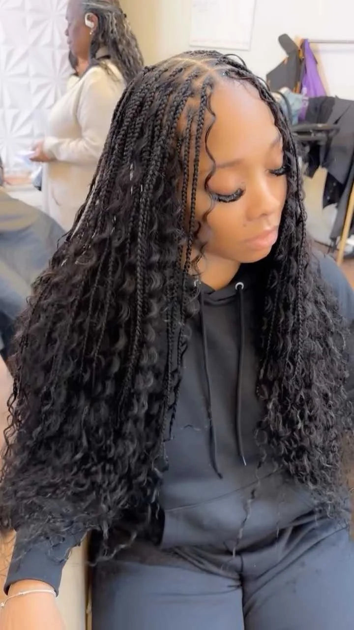 Person with long braided hair sitting in a chair