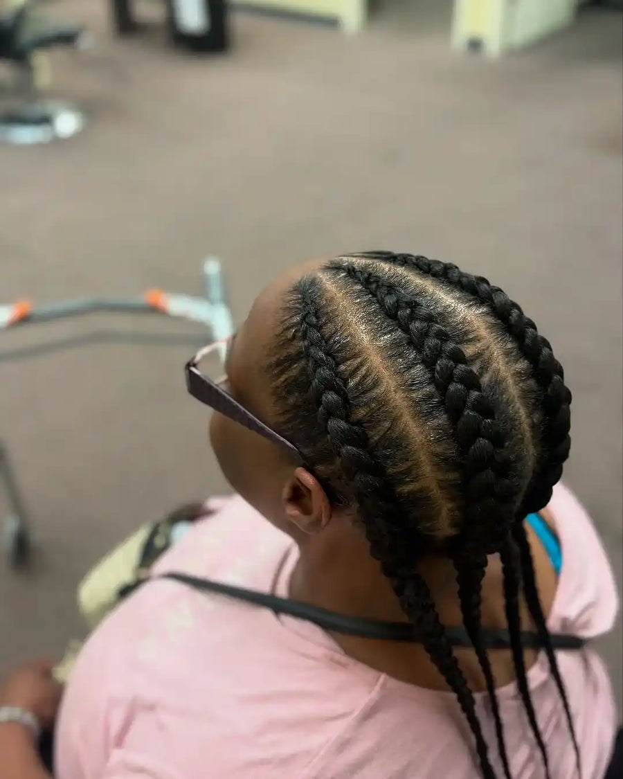 Person with braided hair in a salon setting