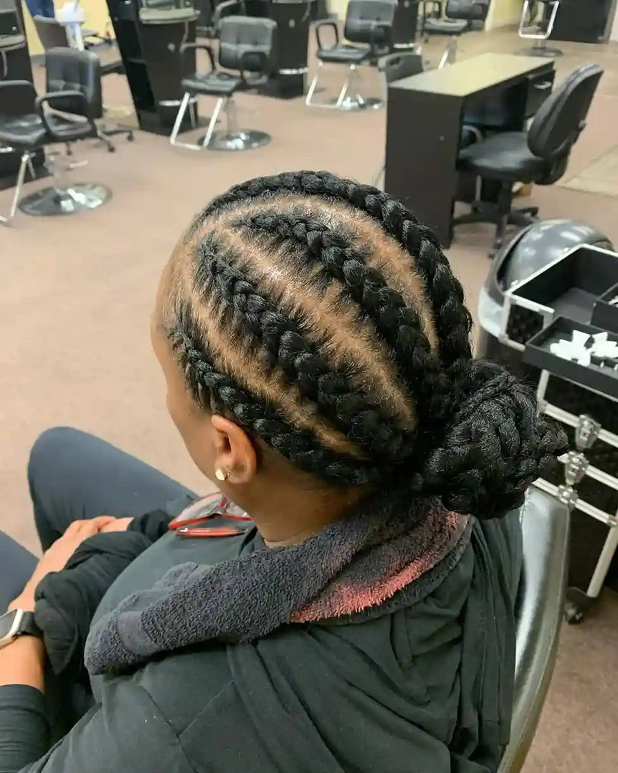Person with braided hair in a salon setting