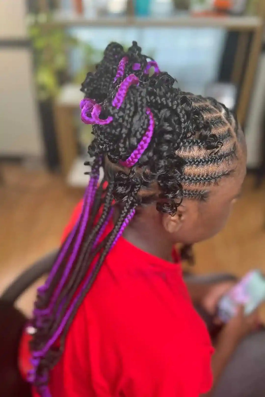 Person with braided hair featuring purple accents in an indoor setting
