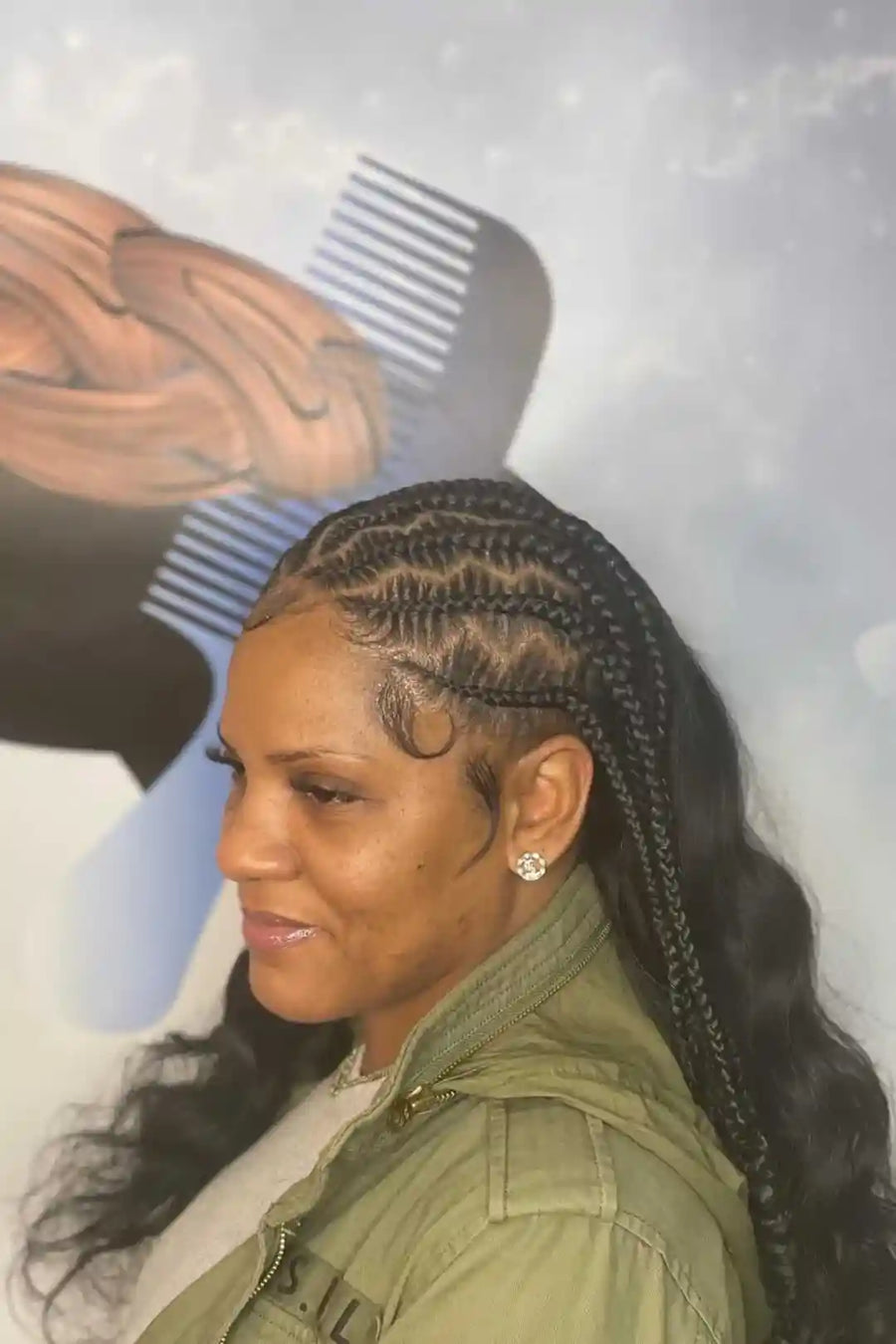 Woman with braided hair and a green jacket against a blurred background