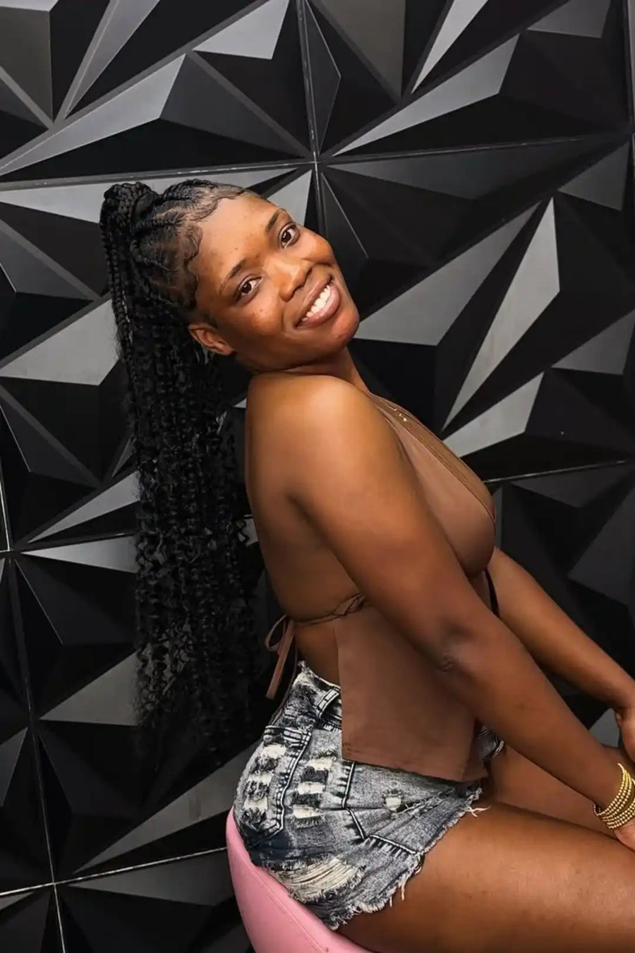 Woman posing against a geometric black and gray wall