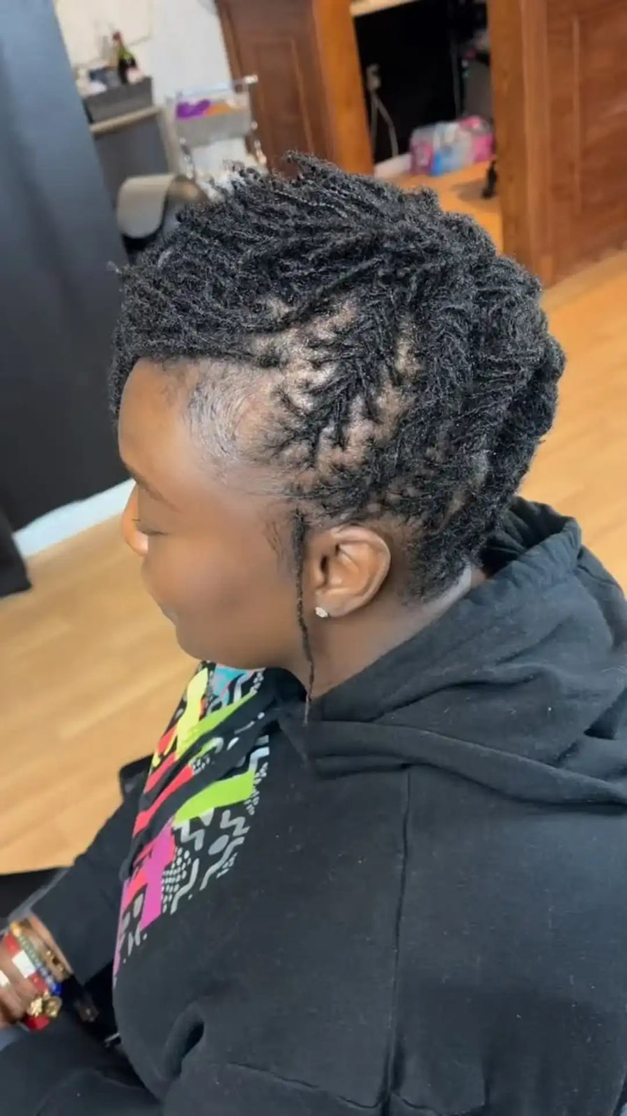 Person with styled hair sitting in a salon chair.