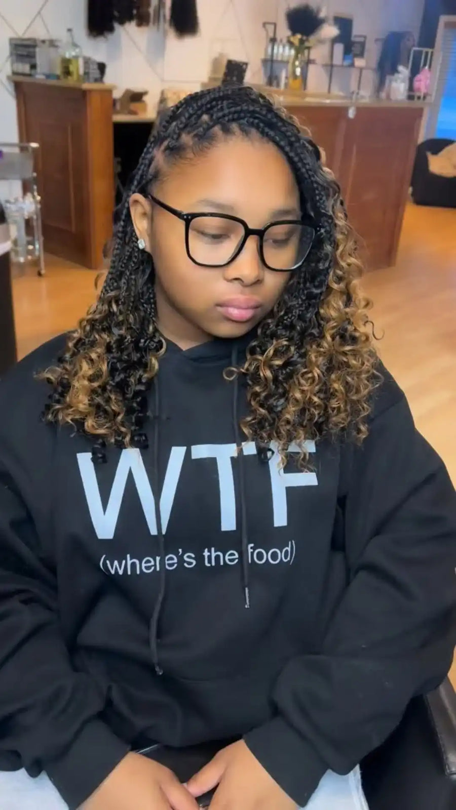 Person wearing a black hoodie with 'WTF where's the food?' text in a casual setting.
