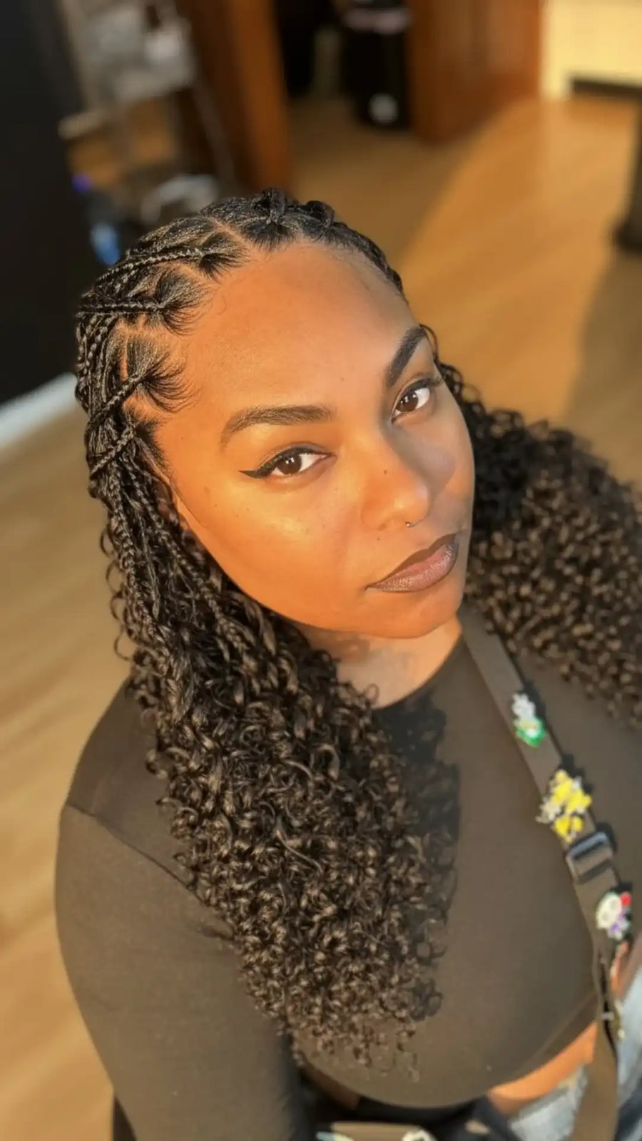 Woman with braided hair looking at the camera indoors.
