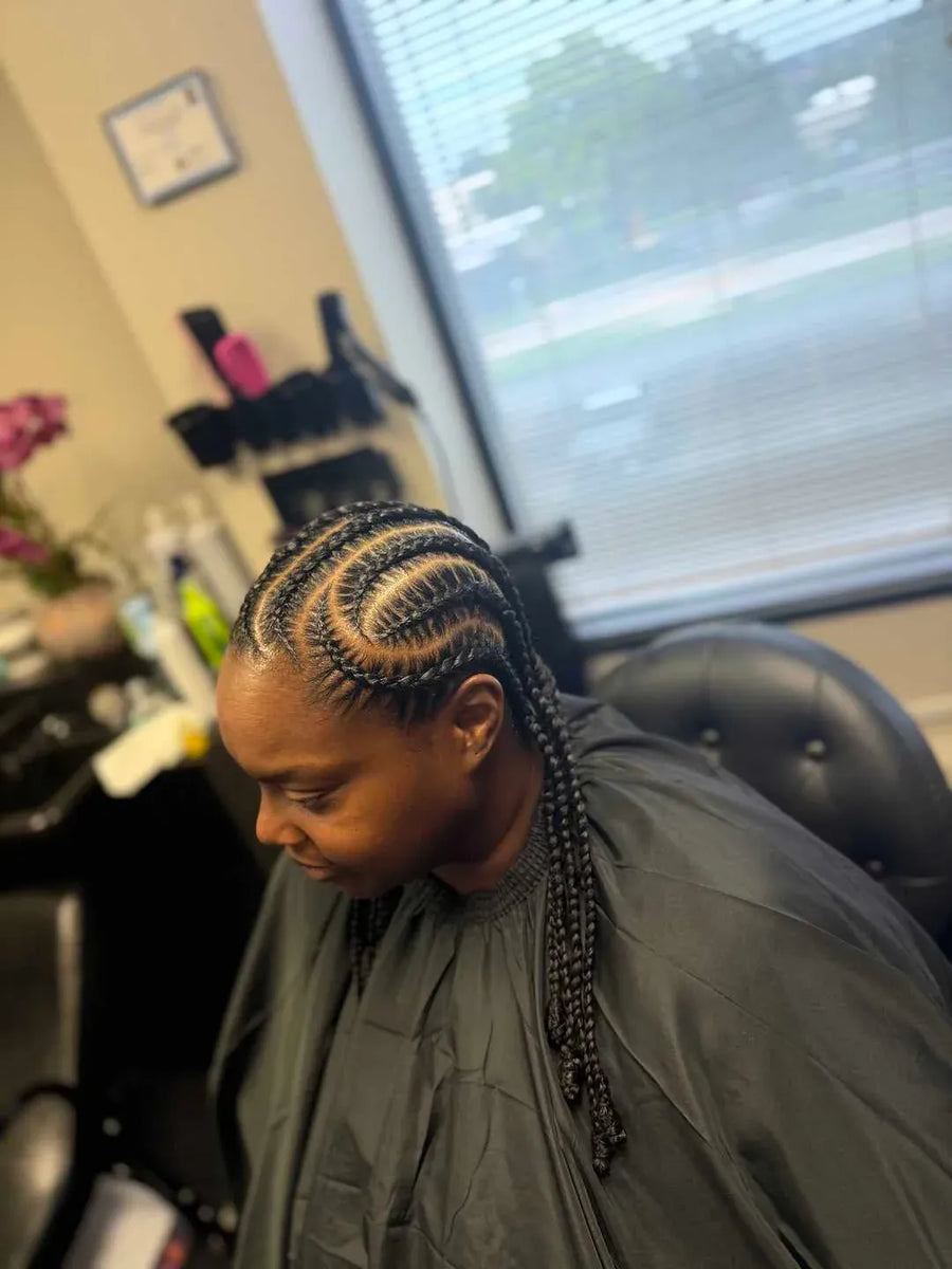 Person with braided hair in a salon setting