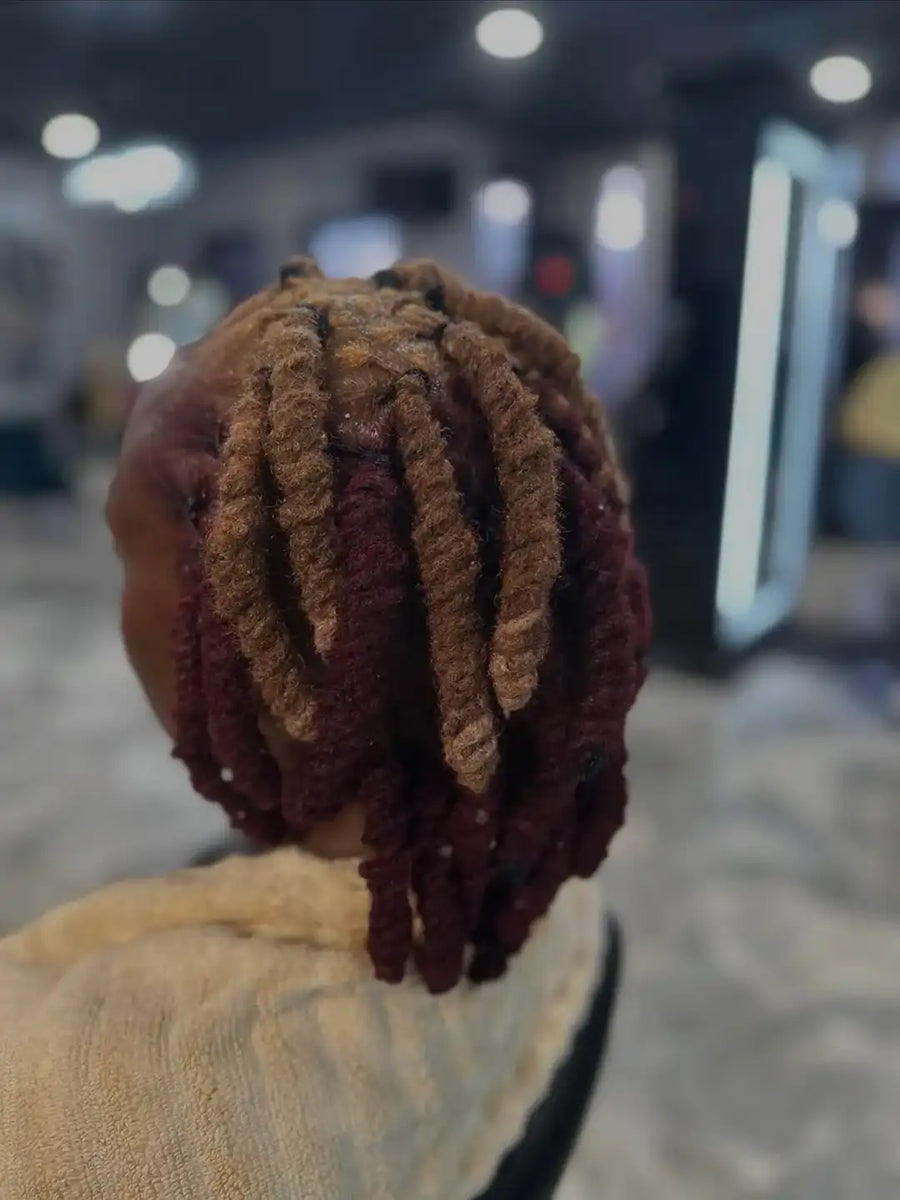 Person with styled hair in a blurred indoor setting