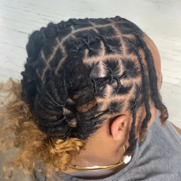 Person with intricately styled braided hair on a light background