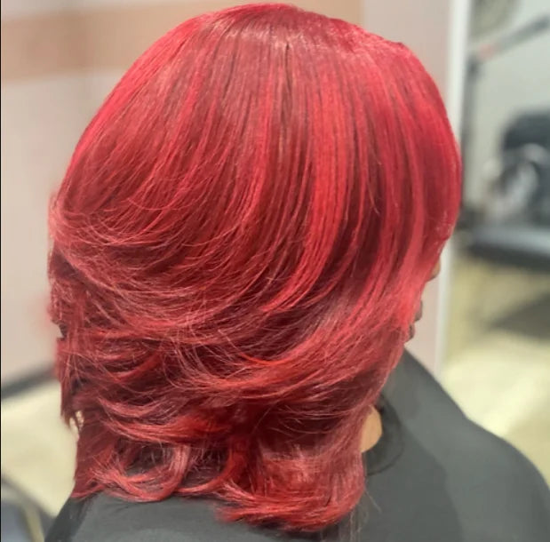 Person with vibrant red hair from behind, blurred background