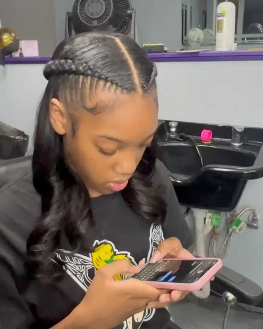 Person using a phone in a salon setting with a sink and hair products in the background.