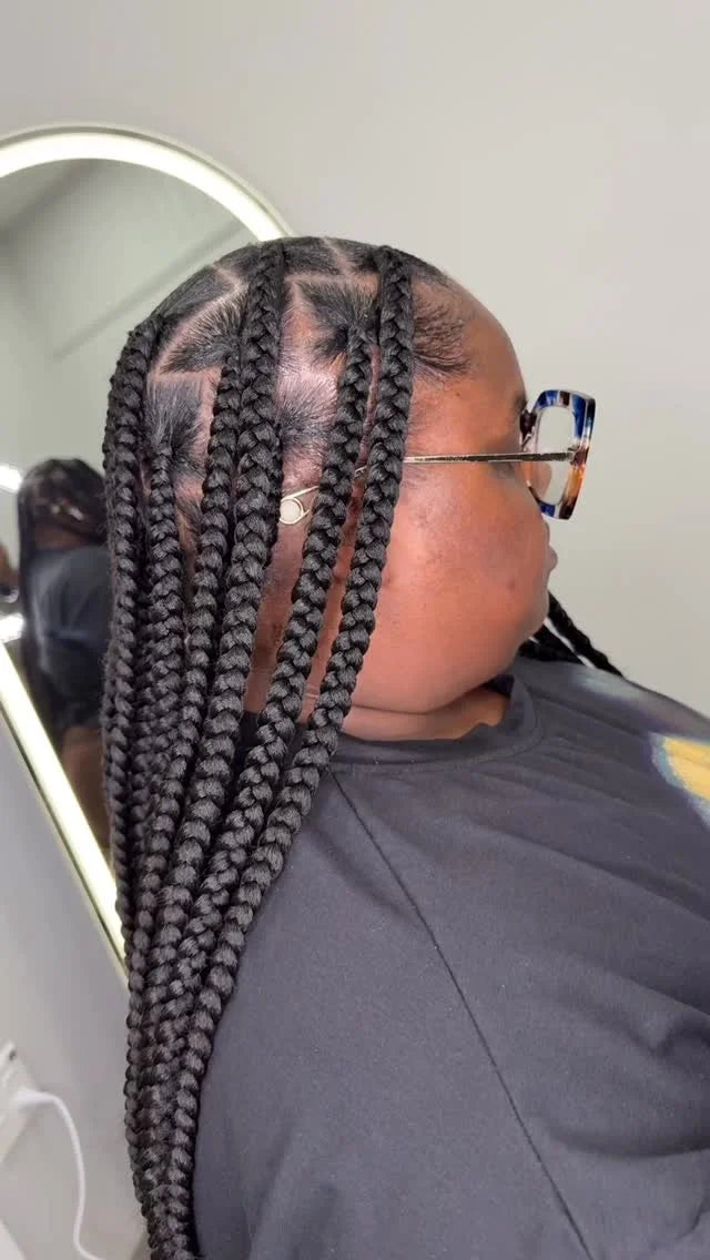 Person with braided hair in a salon setting
