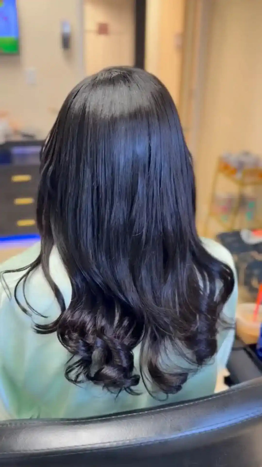Person with long, dark hair in a salon setting
