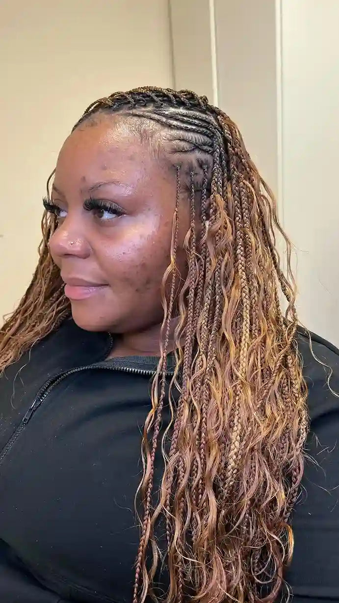 Person with long, braided hair in a neutral setting