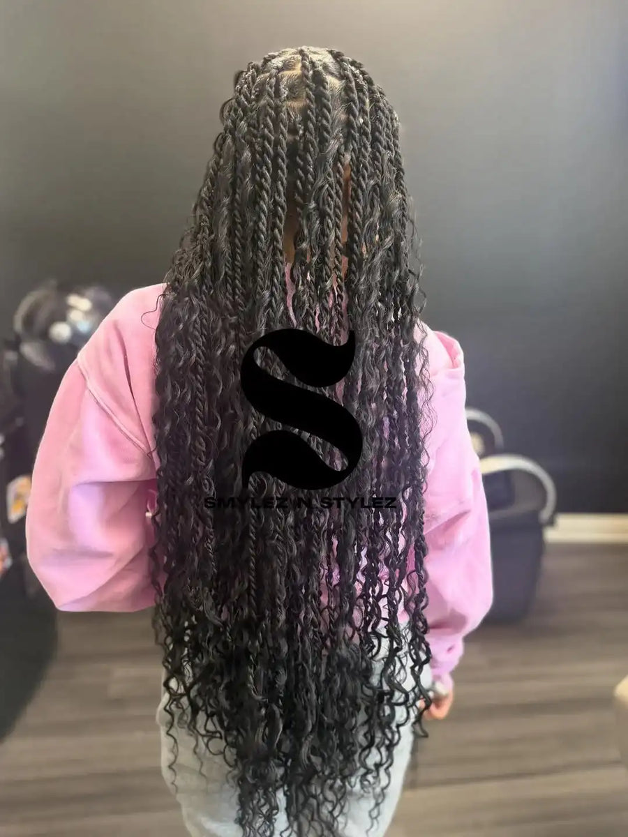 Person with long braided hair wearing a pink sweatshirt, blurred background