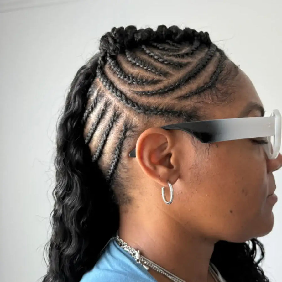 Person with braided hair wearing white sunglasses on a plain background