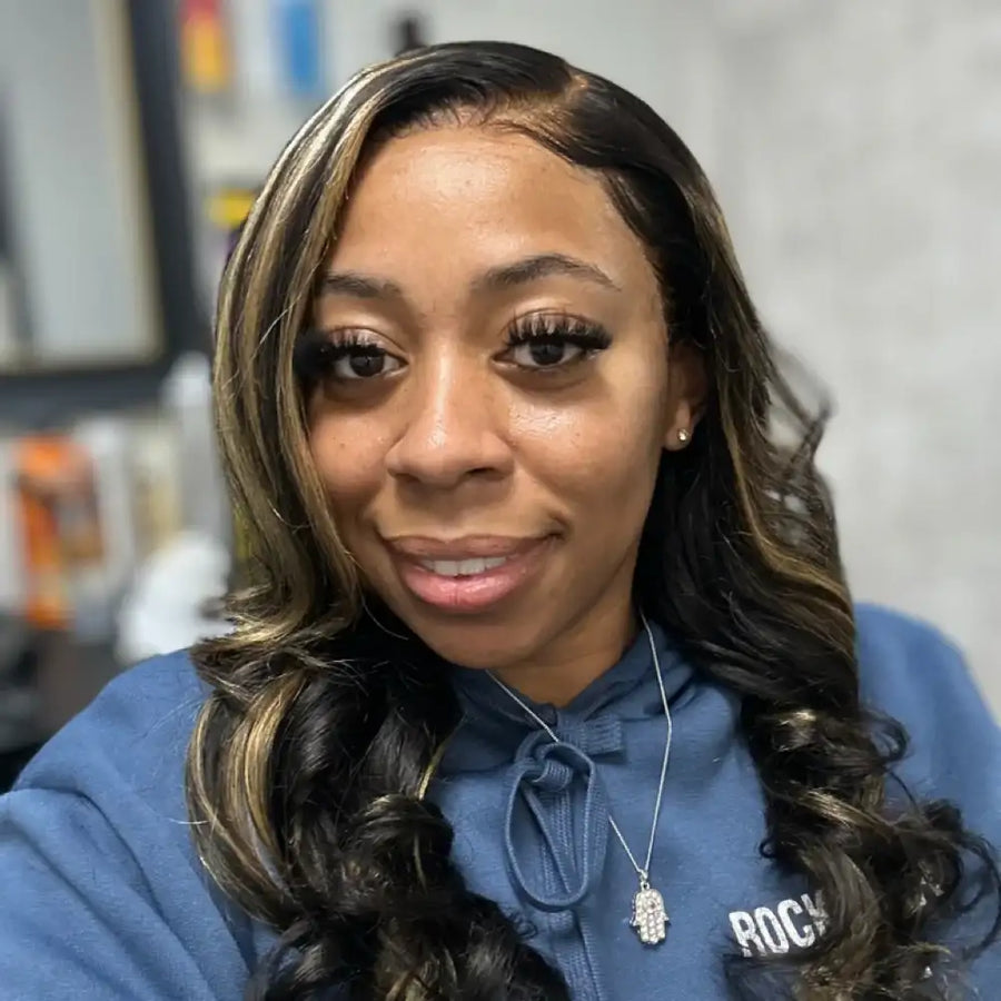 Woman wearing a blue hoodie with a brand logo, smiling at the camera.