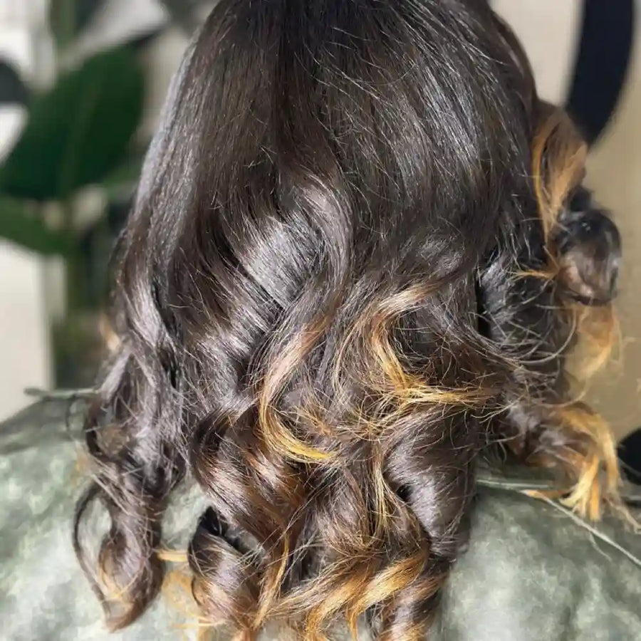 Close-up of wavy hair with blonde highlights on a blurred background