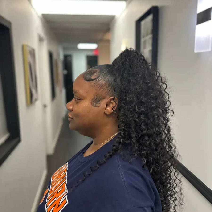 Person with styled hair in a hallway