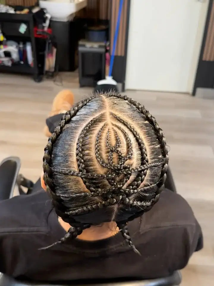 Person with intricate braided hairstyle in a salon setting
