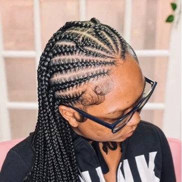 Person with braided hair wearing glasses and a black shirt with white text.