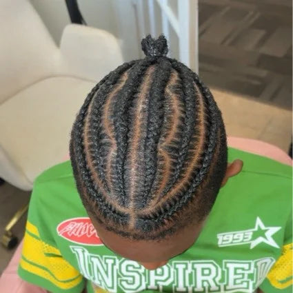 Person with braided hair wearing a green shirt with visible text.