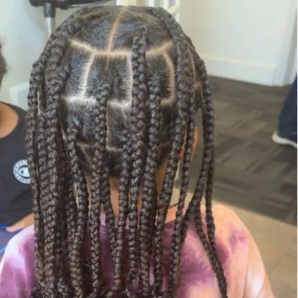 Person with braided hair in a salon setting