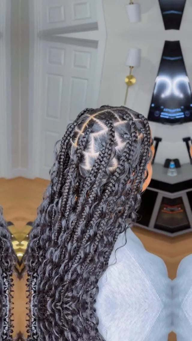 Person with braided hair sitting in a room with a door and lamp visible.