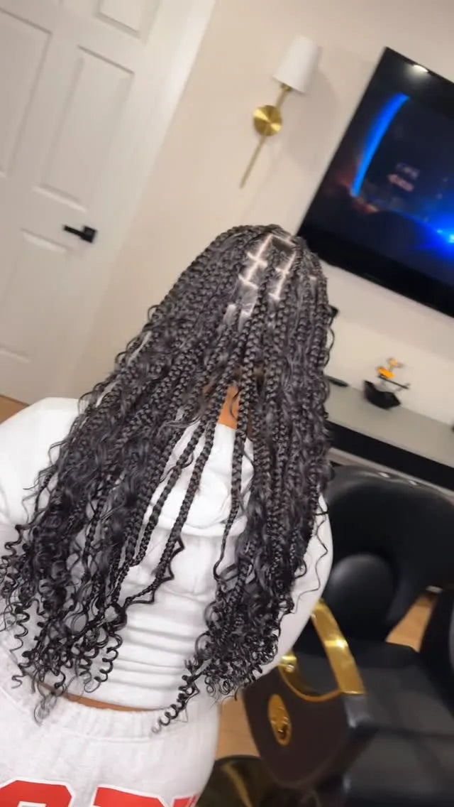 Person with braided hair in a room with a television and door in the background