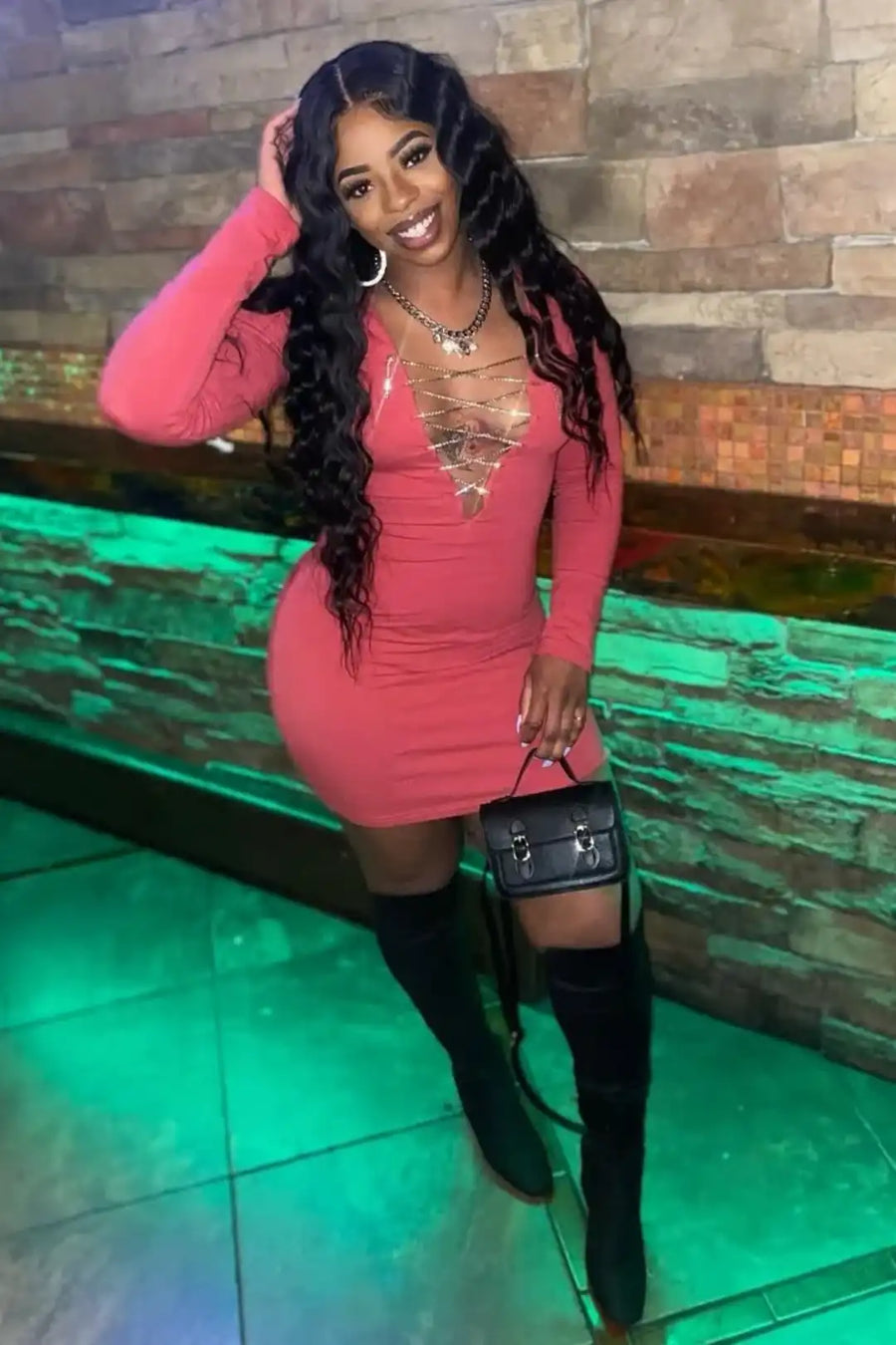 Woman in a pink dress with a stone wall background