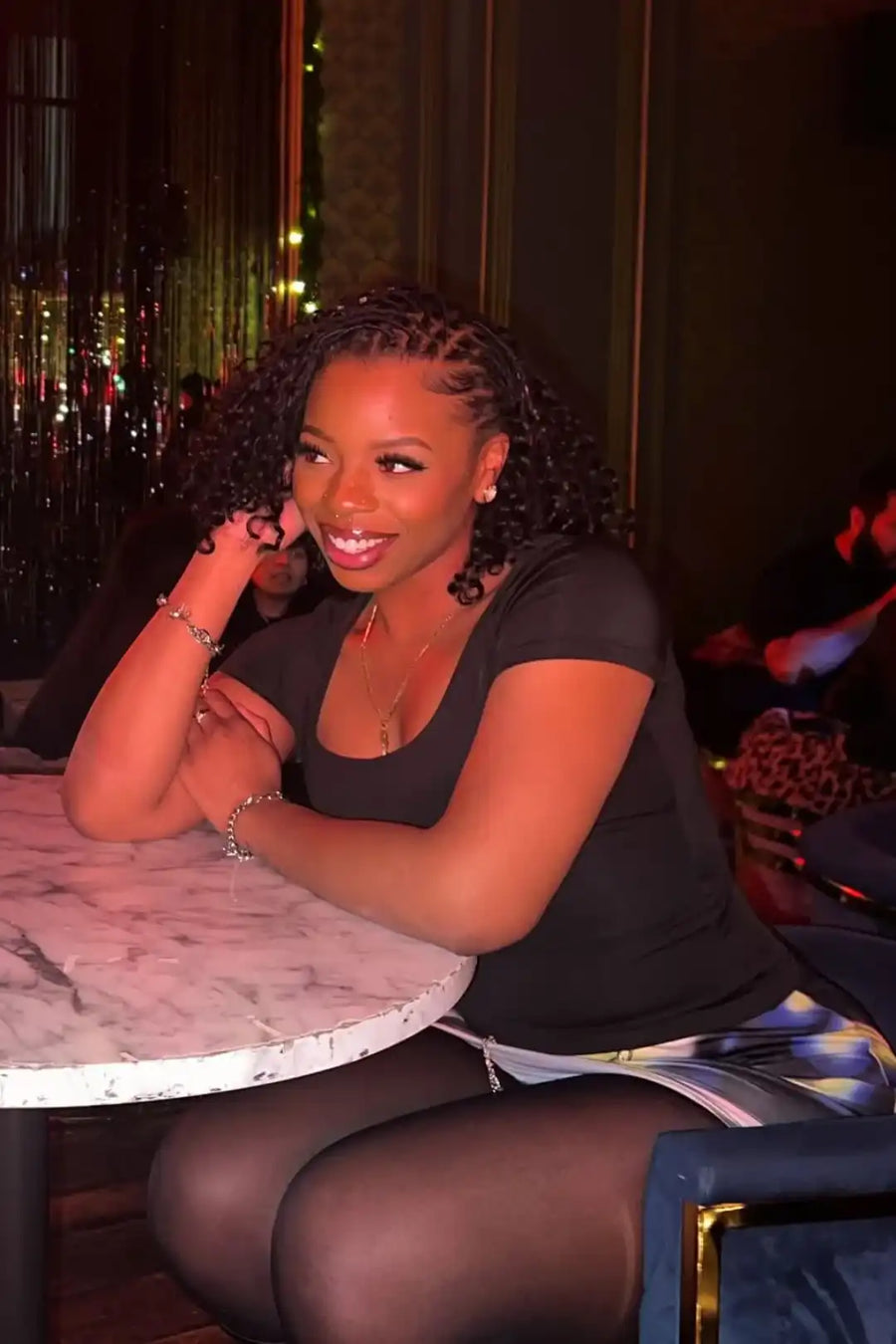 Woman sitting at a table in a dimly lit indoor setting
