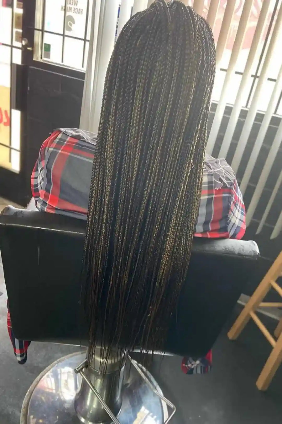 Long braided wig on a mannequin head in a salon setting