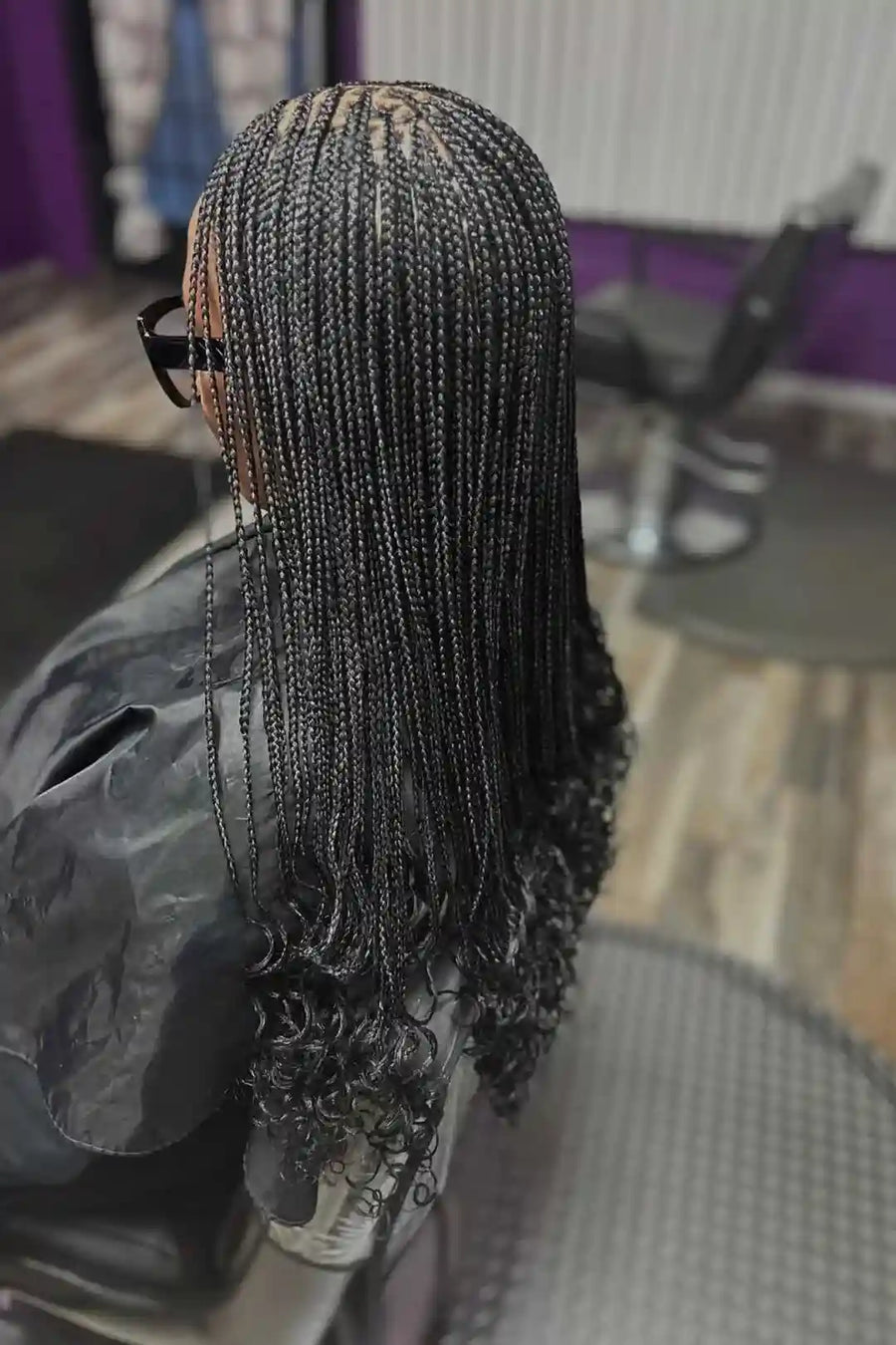 Person with braided hair in a salon setting
