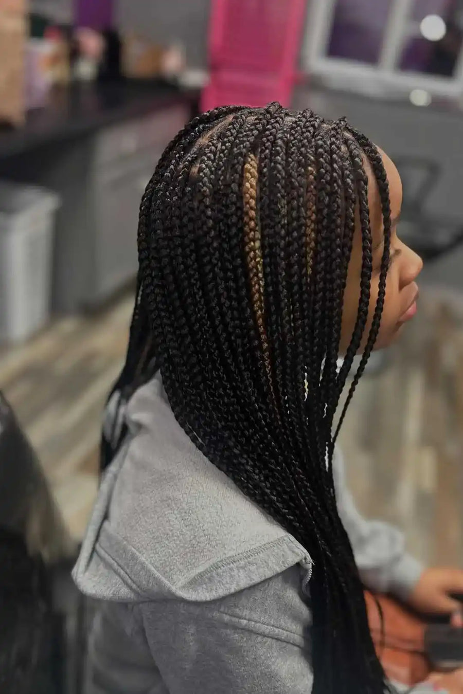 Person with braided hair in a salon setting