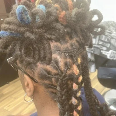 Person with braided hair styled in cornrows with colorful beads.