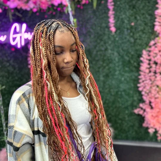 Woman with colorful braids standing in front of a floral background