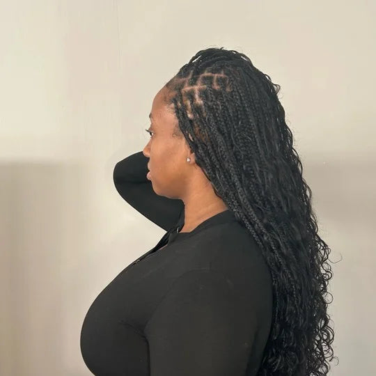 Woman with styled hair wearing a black face mask against a neutral background