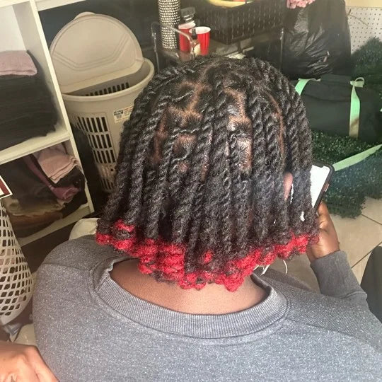 Person with braided hair featuring red ends in a casual indoor setting