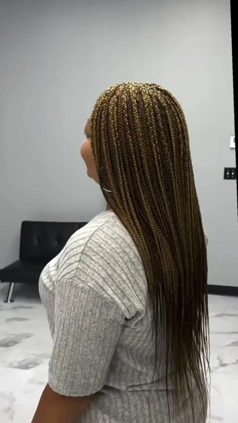Person with braided hair in a salon setting