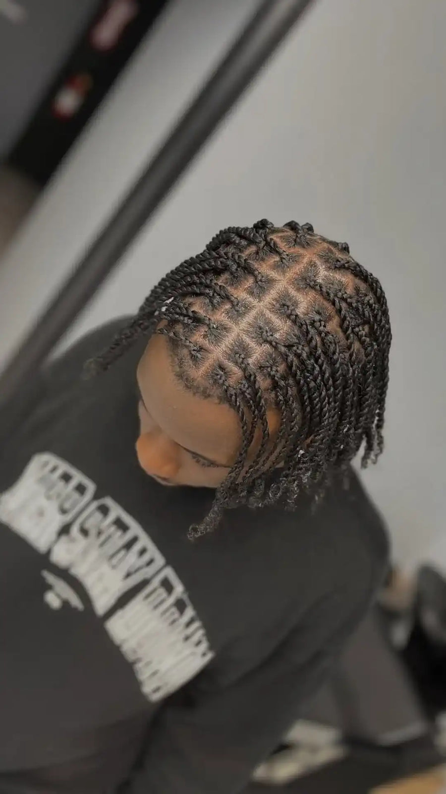 Mannequin head with braided hair against a blurred background