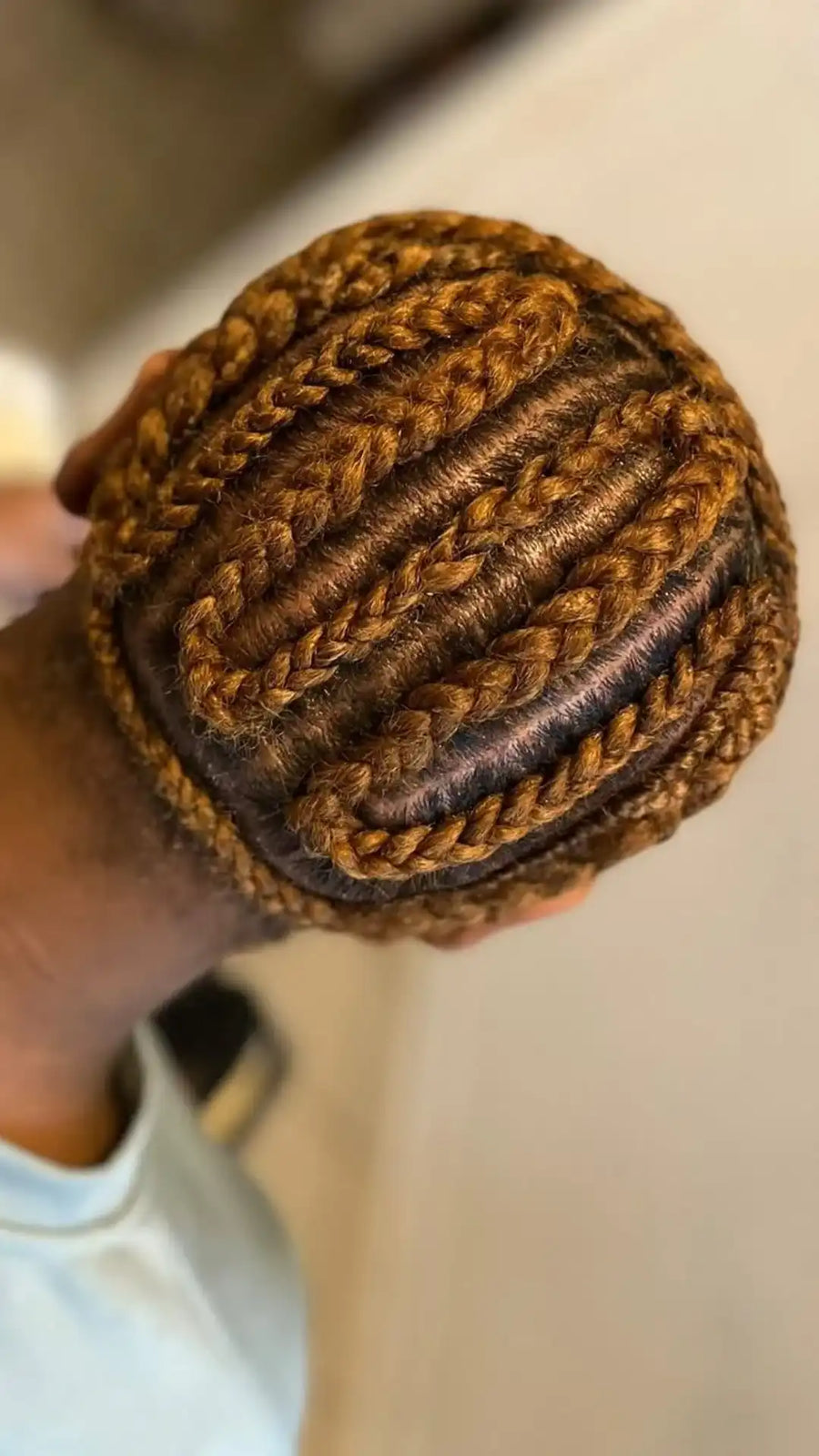 Brown knitted ball held by a hand against a blurred background