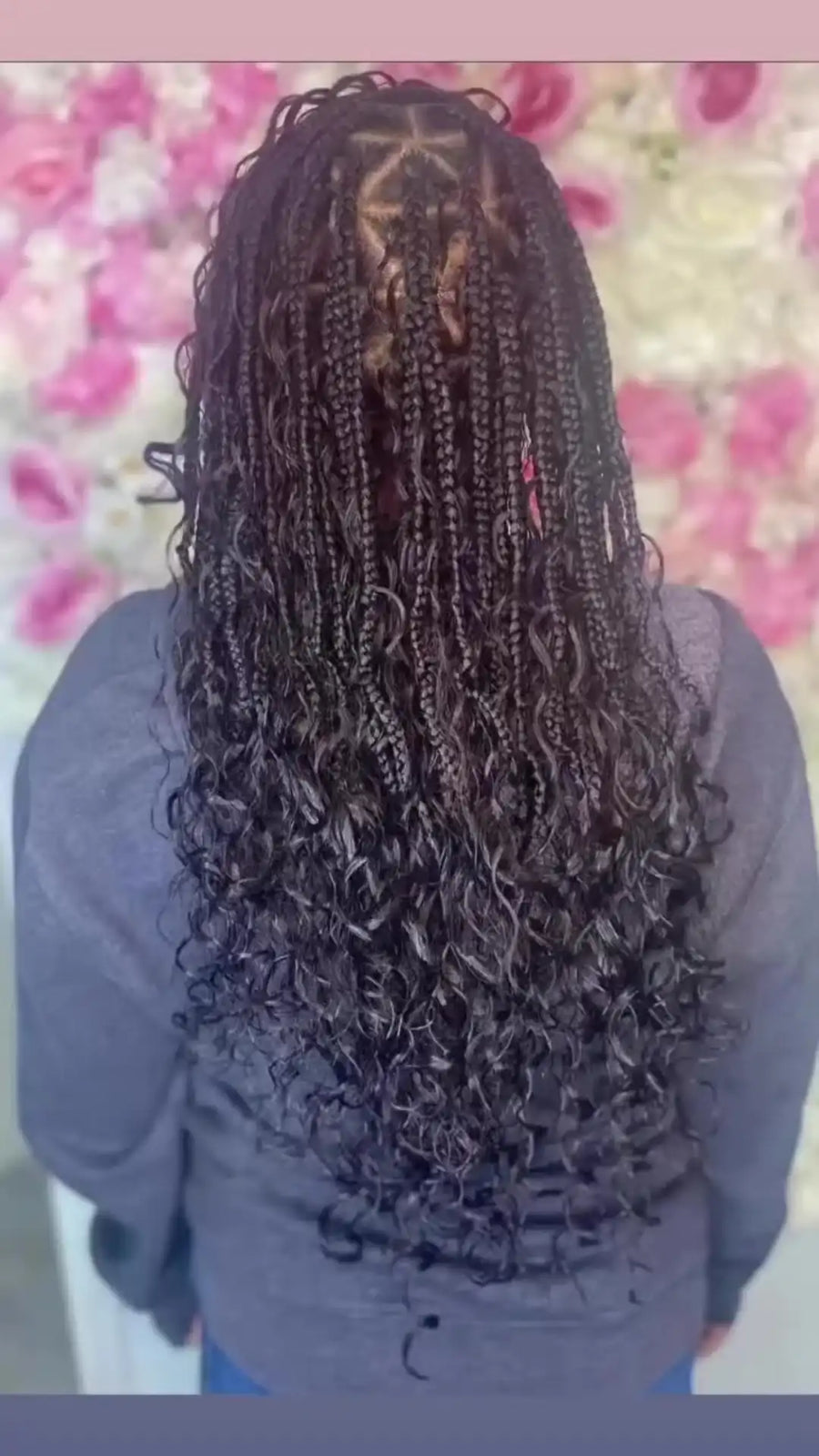 Person with braided hair against a blurred floral background
