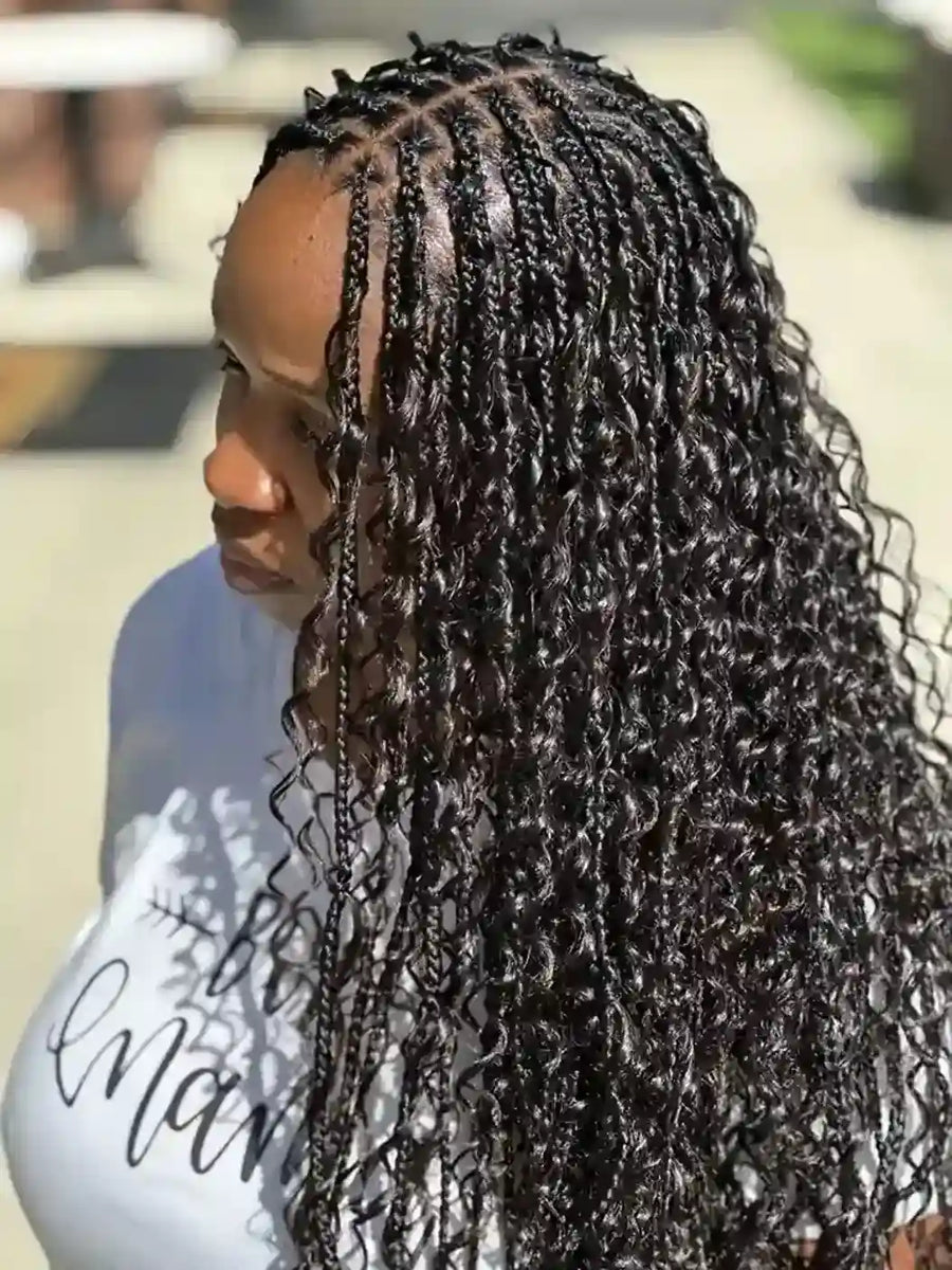 Person with braided hair wearing a white shirt with text.