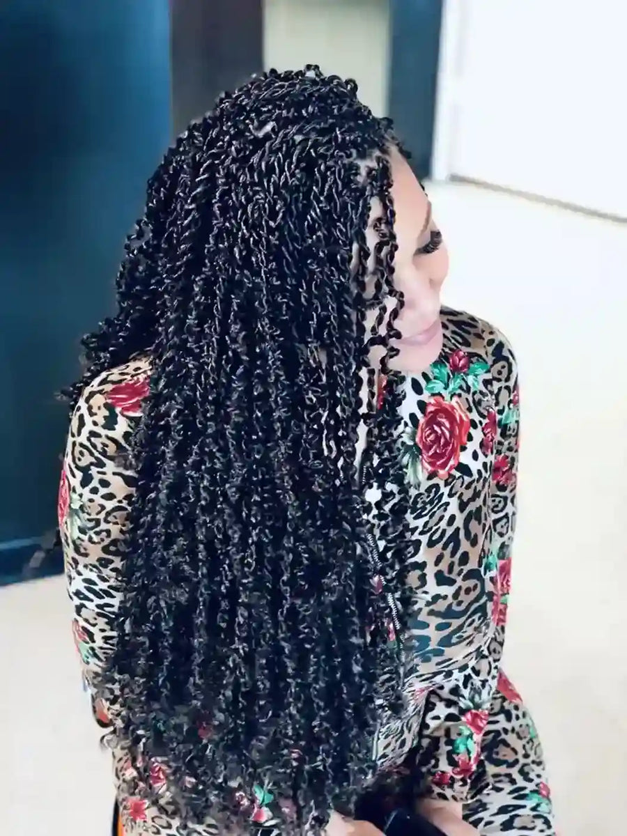 Woman with braided hair wearing a leopard print top with floral patterns.