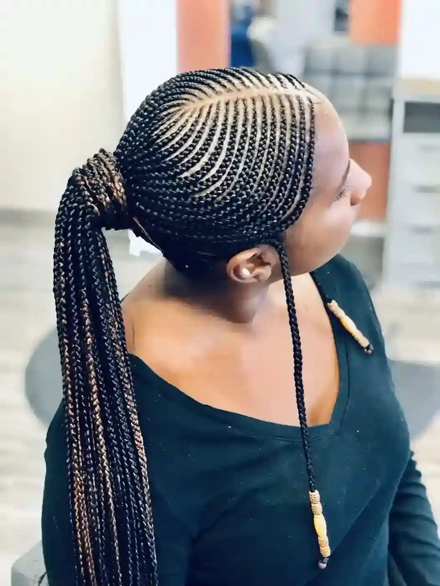 Person with braided hair styled in a high ponytail, wearing a black top.